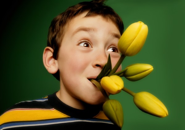 dreng med blomster i munden